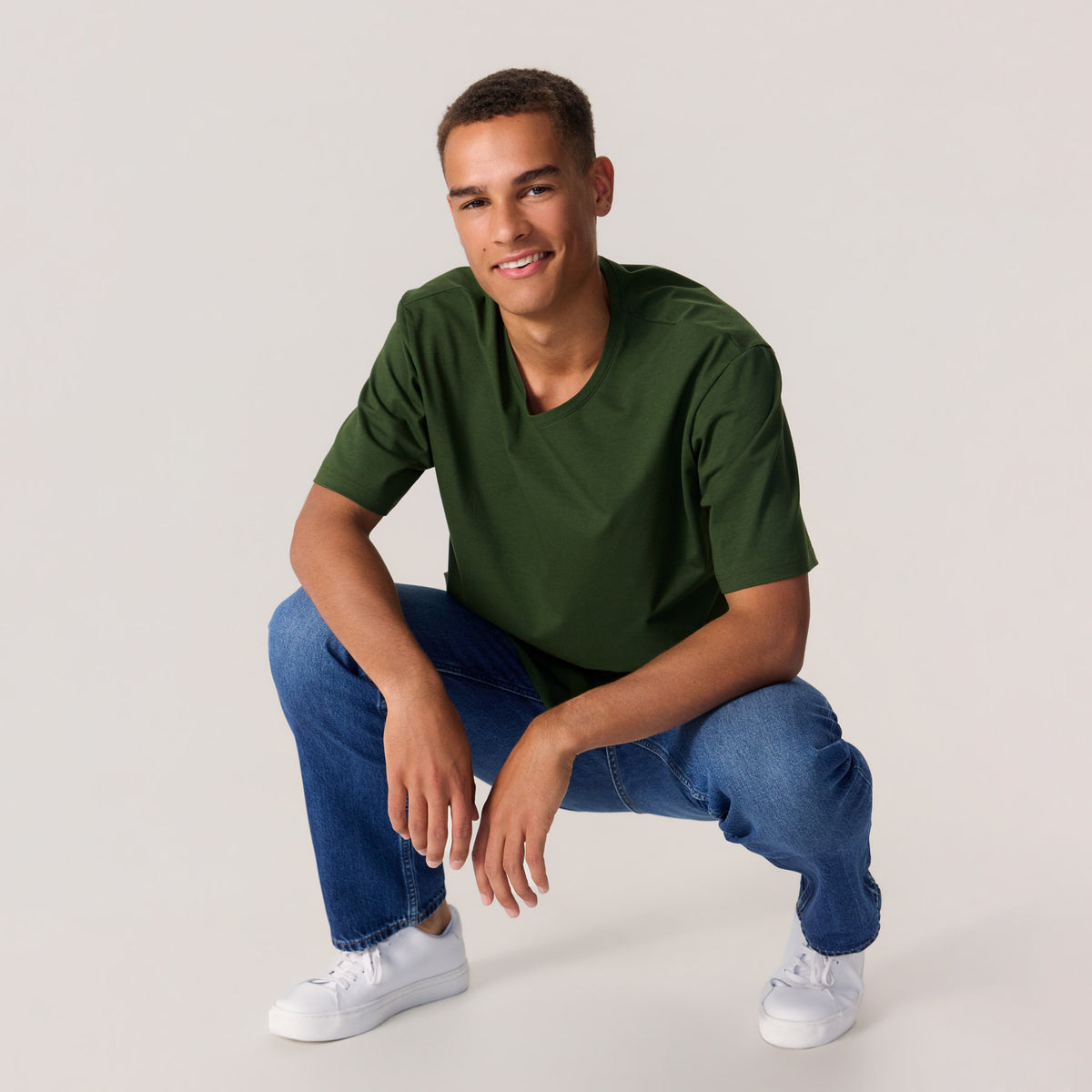 Miesmalli maastonvihreässä unisex-mallisessa t-paidassa, missä pyöreä pääntie
