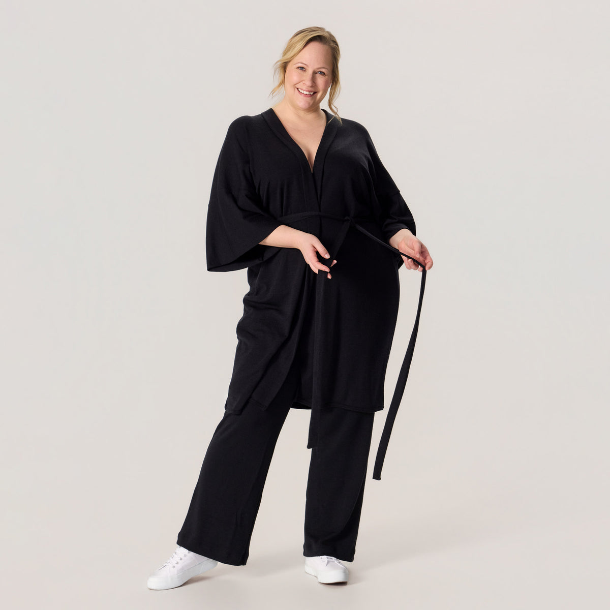 HAIKU kimono ja rennot neulehousut merinovillasta. Mallilla on jalassa valkoiset tennarit, ja asukokonaisuus on rento ja näyttävä arkeen.